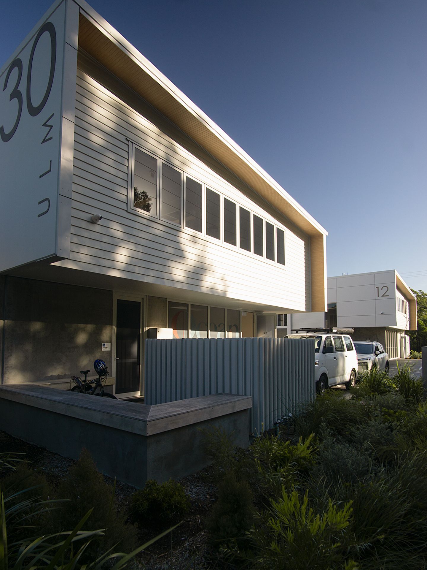 Modern two-story white residential building labeled 