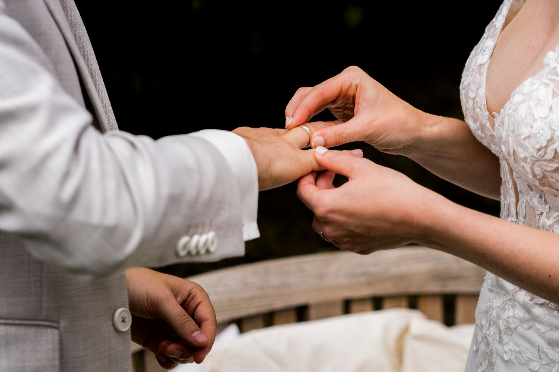 De bruid schuift de ring om de vinger van de bruidegom tijdens de huwelijksceremonie.