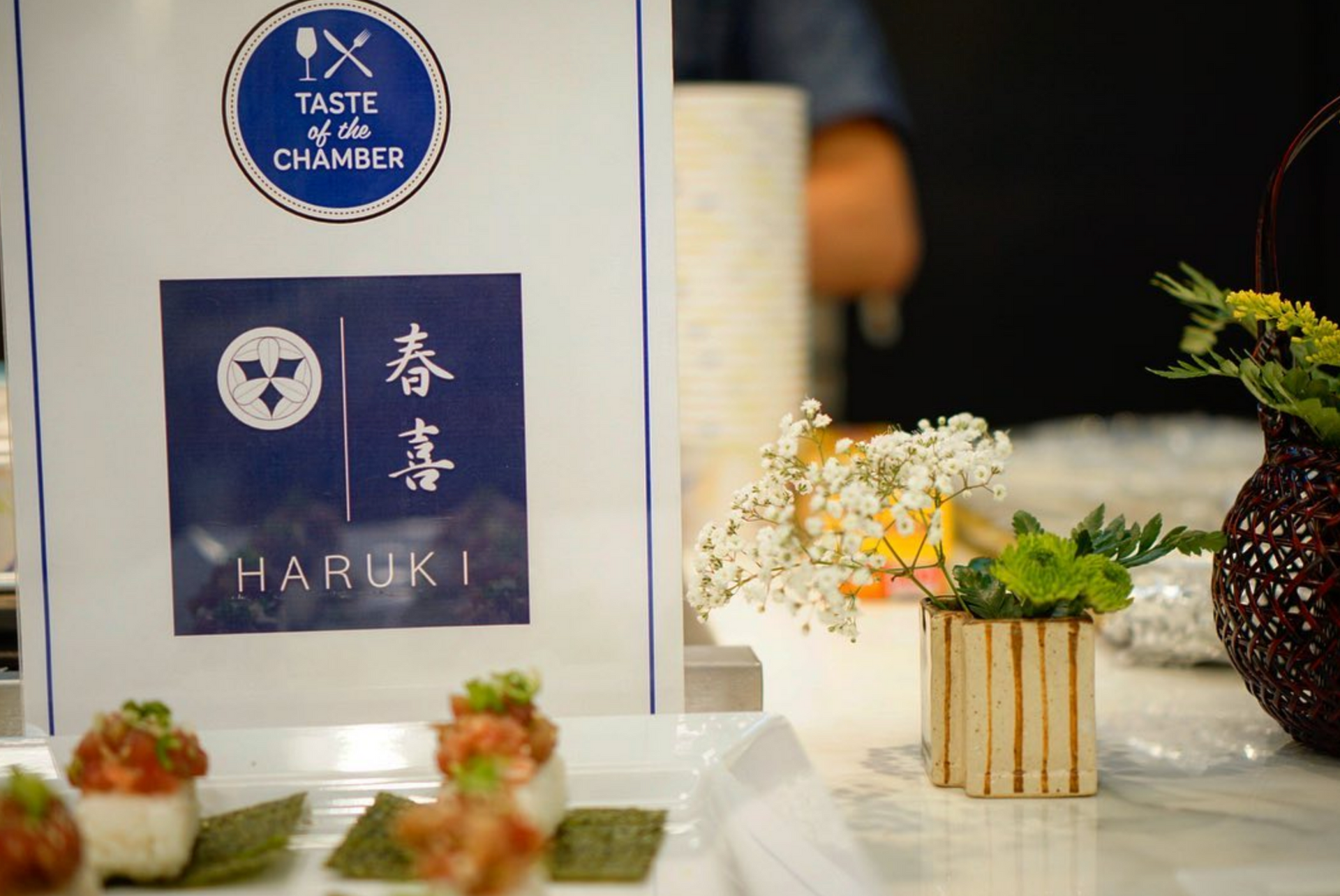Sign for Haruki restaurant with sushi on display at a