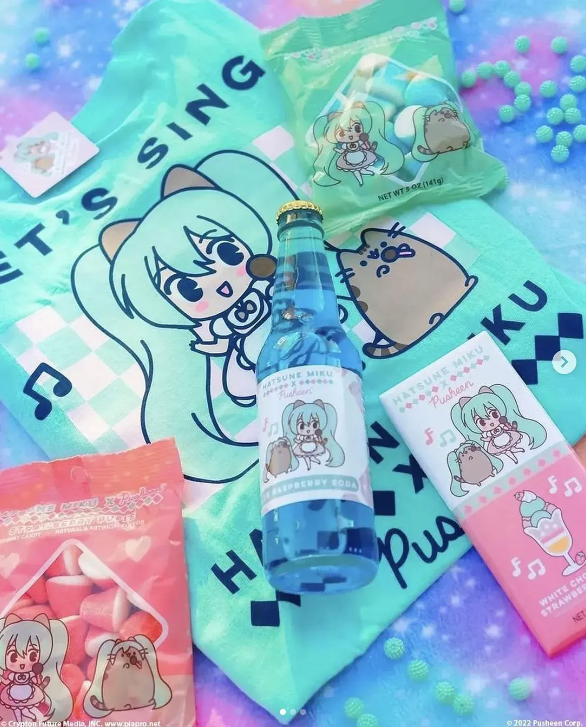 Collection of Hatsune Miku and Pusheen themed merchandise, including soda, candy, and a towel, on a colorful background.