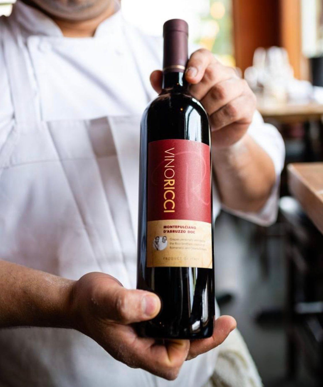 Chef holding a bottle of red wine, 