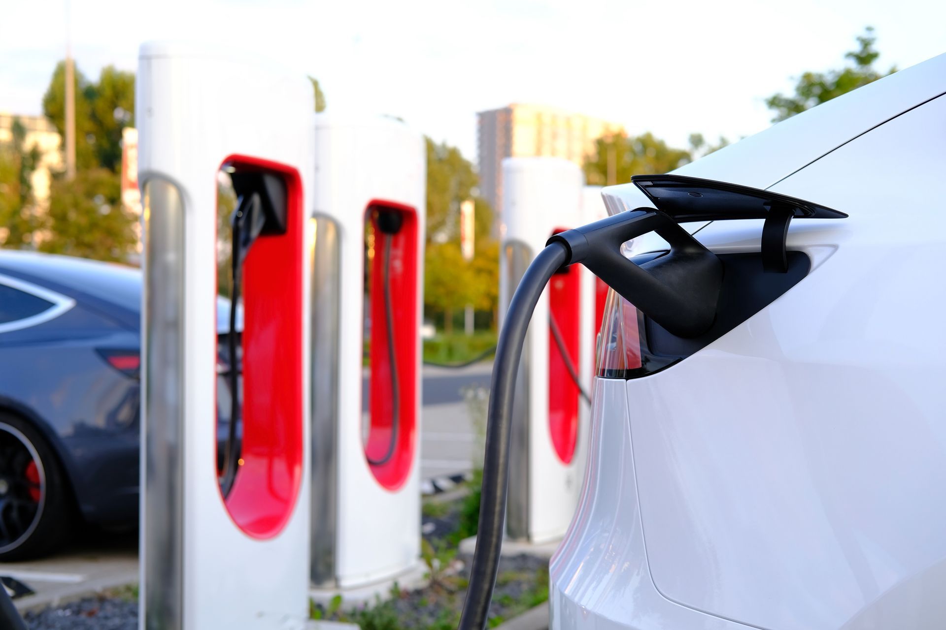 White Electric Car Is Being Charged at A Charging Station