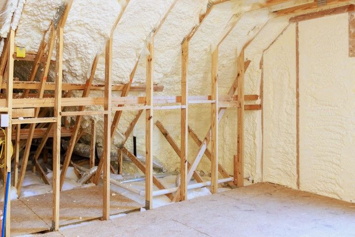 Spray-foam insulated attic with exposed wooden framing and open floor space