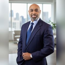 A man in a suit and tie is smiling for the camera.