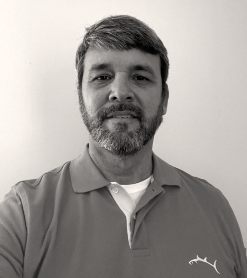 Man with beard wearing a red polo shirt, smiling, in front of a white wall. Michael Alsup
