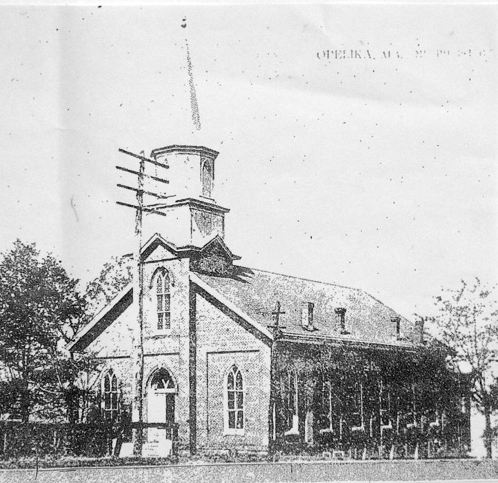 Black and white photo of a brick church in Opelika, AL, with steeple, crosses, and power lines. Methodist Church Opelika