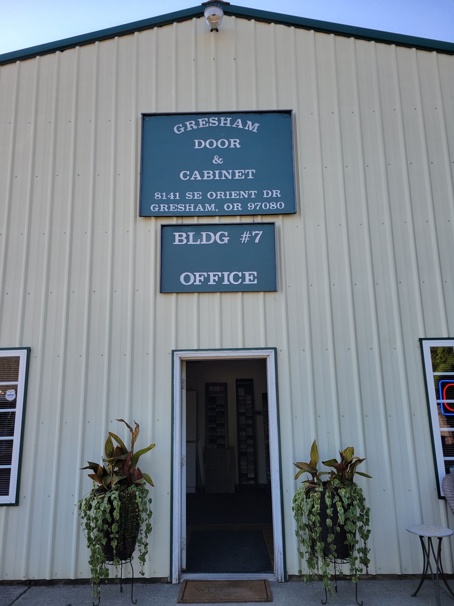 Exterior of a beige building with blue signs reading “Surgery Center,” “Suite #7,” and “Office” above the entrance