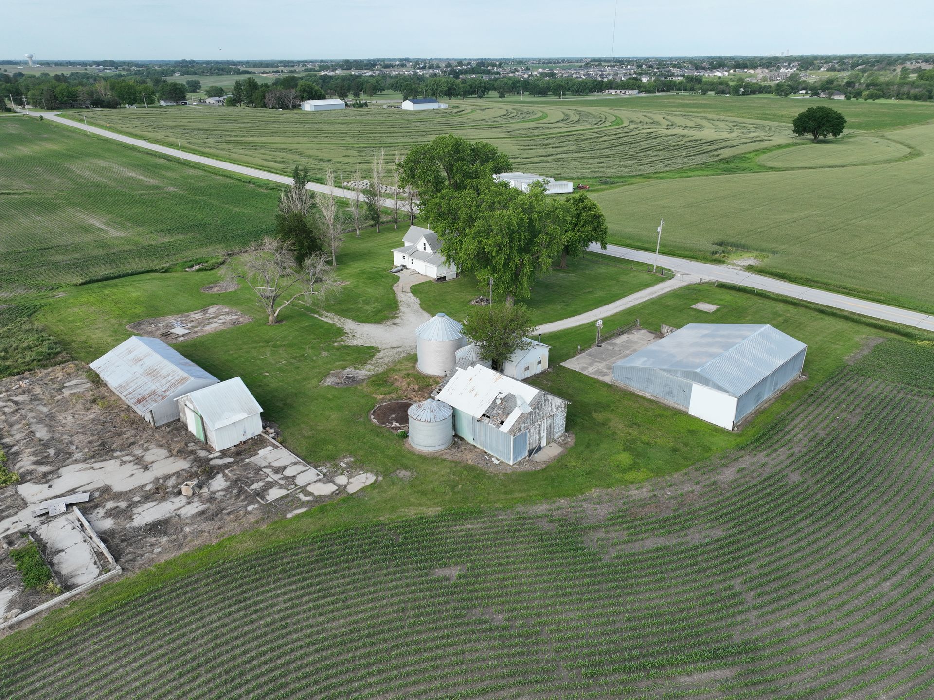 An aerial view of a farm with a road going through it