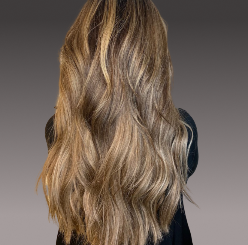 The back of a woman's head with long beautiful hair that has extensions.