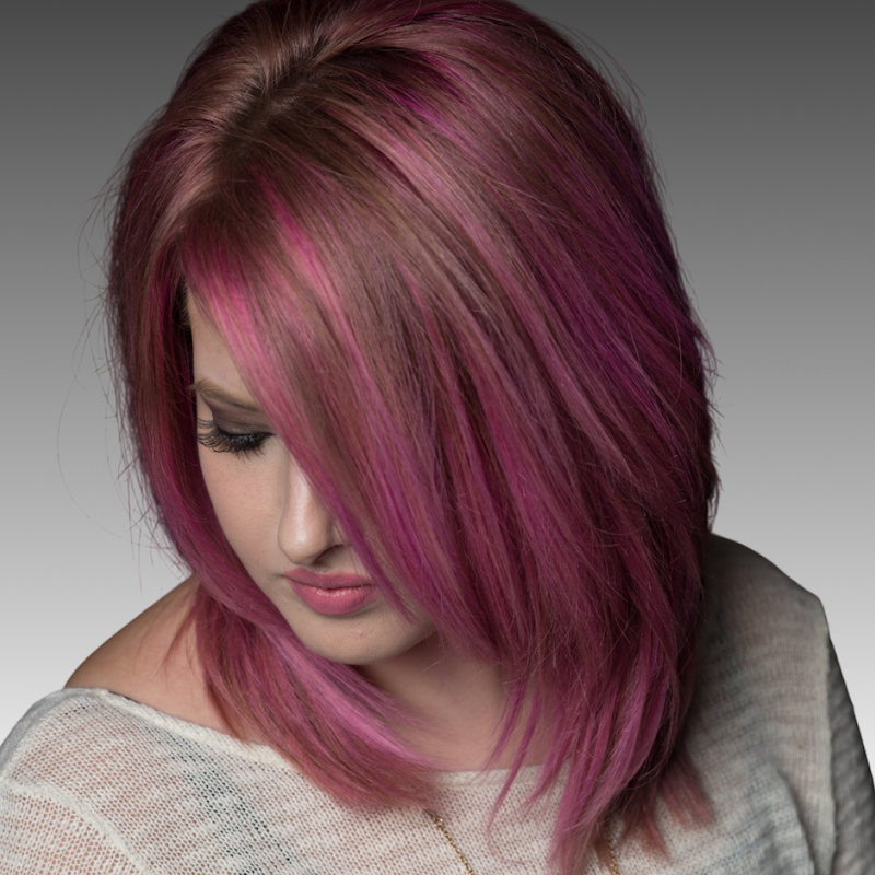 Woman with brown hair and pink highlights.