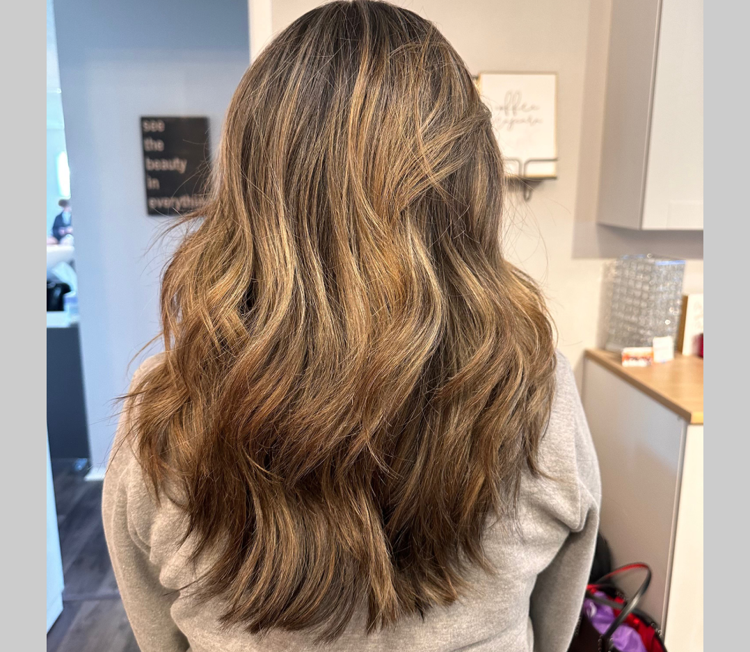 After picture of a woman's hair that looks brown and wavy and pretty.
