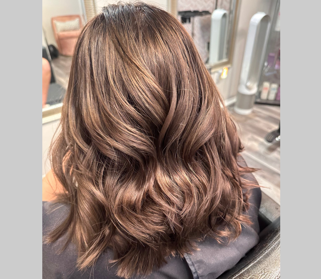 After picture of a woman's hair. It is brown and wavy.