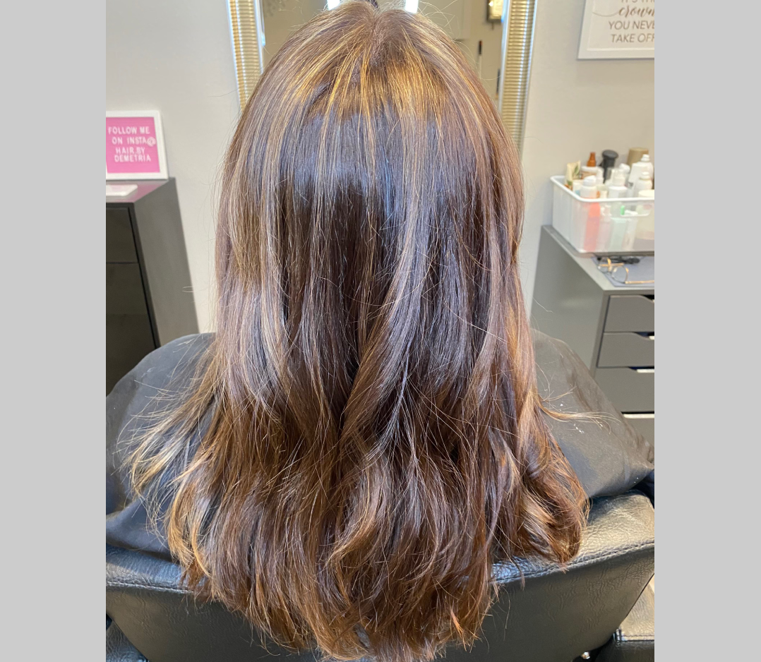 After picture of a woman with smooth shiny hair with soft pretty highlights.