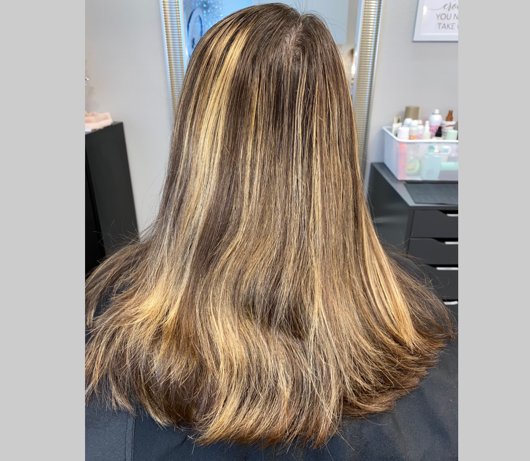 Before picture of a woman's hai that is brown and streamed with too many highlights.