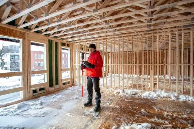 un homme se tient à l' intérieur d' un bâtiment en construction .