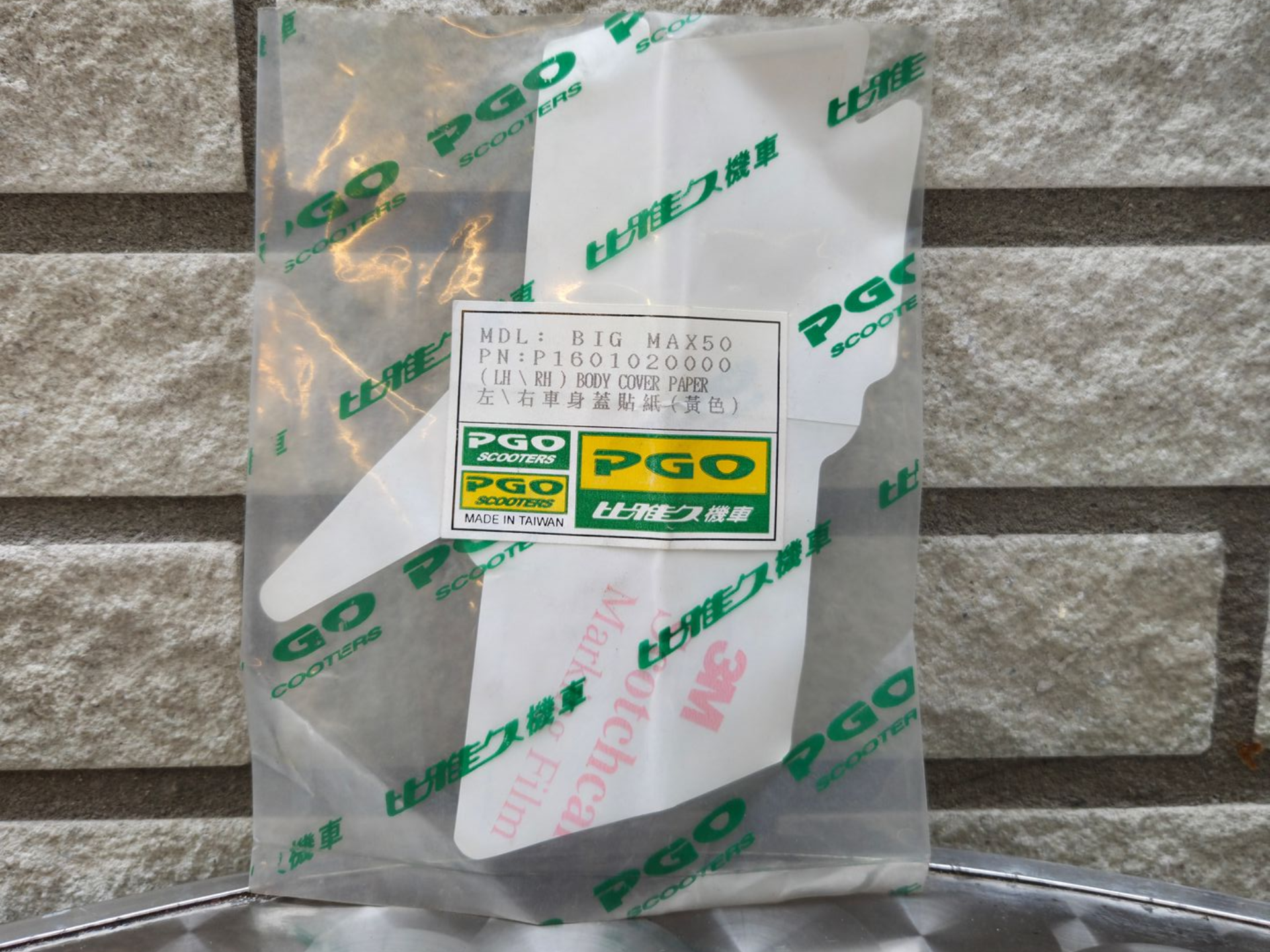 Verpakte Japanse snack in een doorzichtige plastic verpakking tegen een stenen muur op de achtergrond.