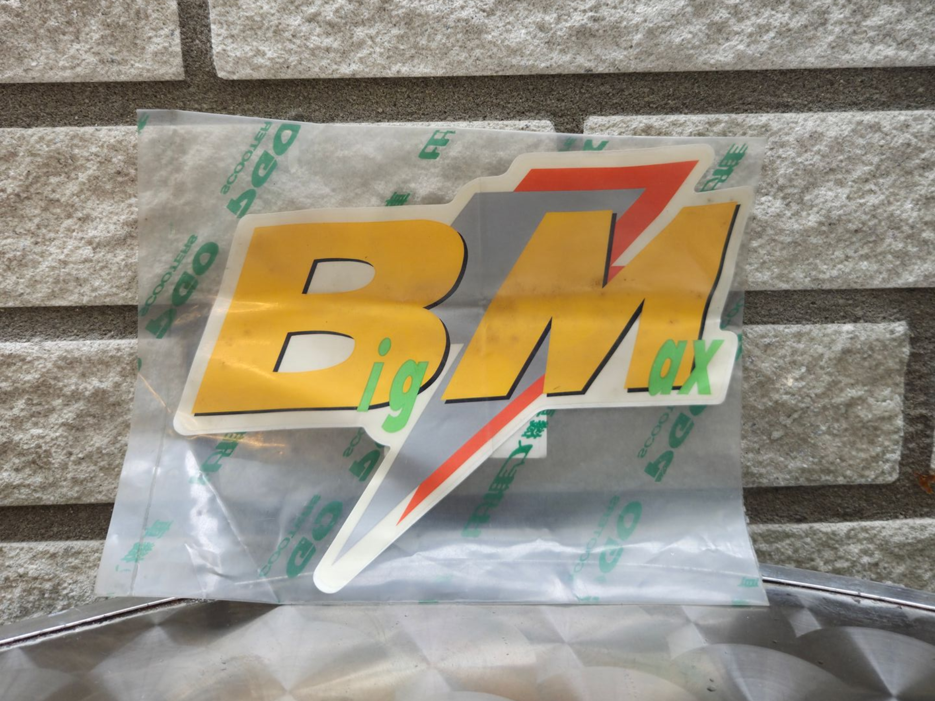 Verpakte Japanse snack in een doorzichtige plastic verpakking tegen een stenen muur op de achtergrond.