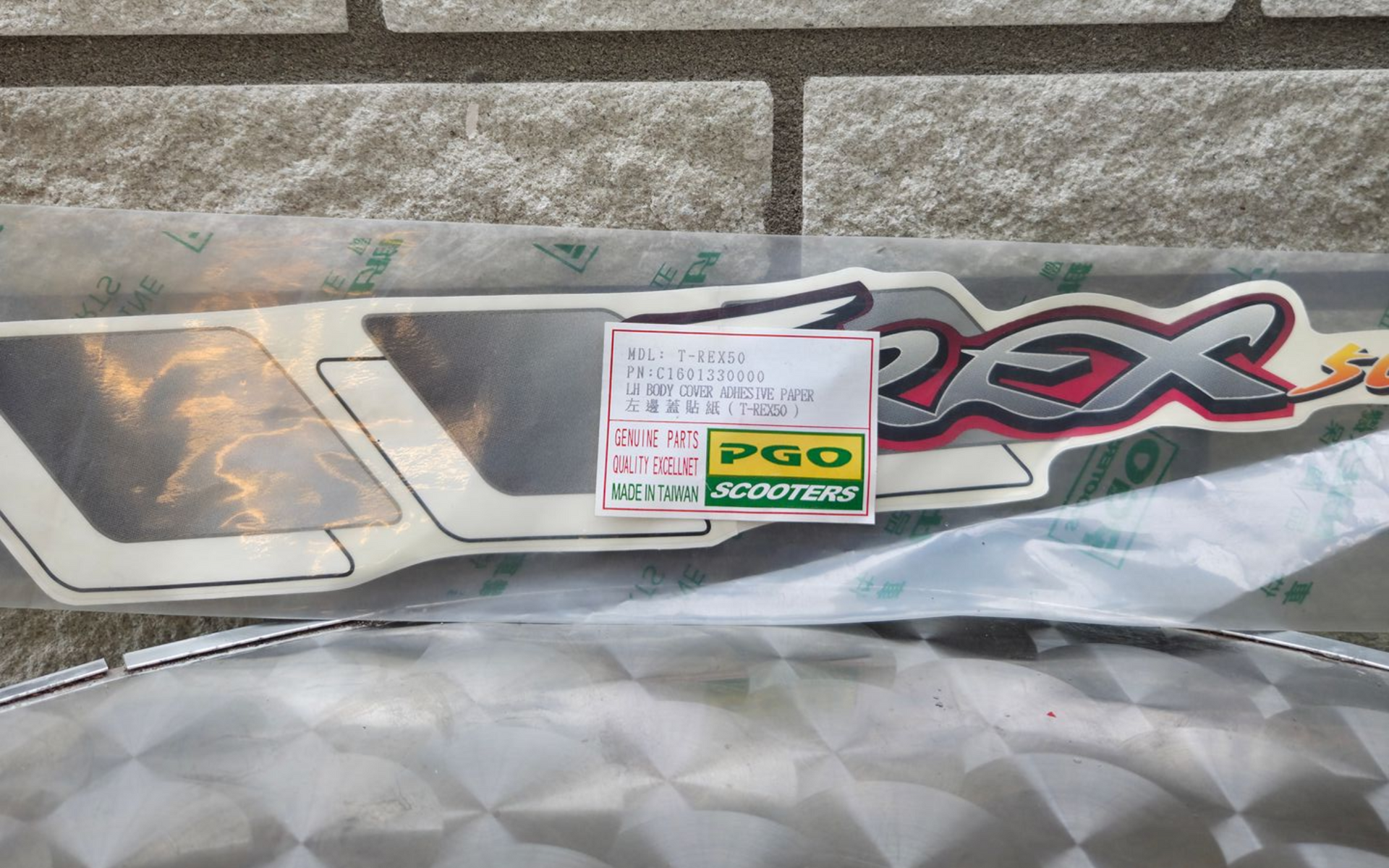 Close-up van een glanzende zilveren en rode RC-autocarrosserie met een klein certificeringsstickertje erop.