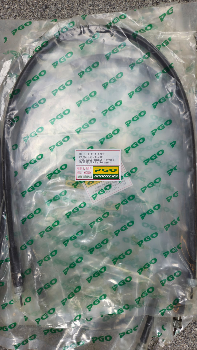 Doorzichtige, in plastic verpakte zwarte kabel met een klein geel-wit label op een groene achtergrond met patroon.