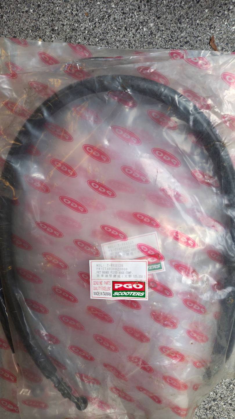 Zwarte opgerolde kabel in een doorzichtige plastic zak met rode opdruk op een grijze ondergrond.