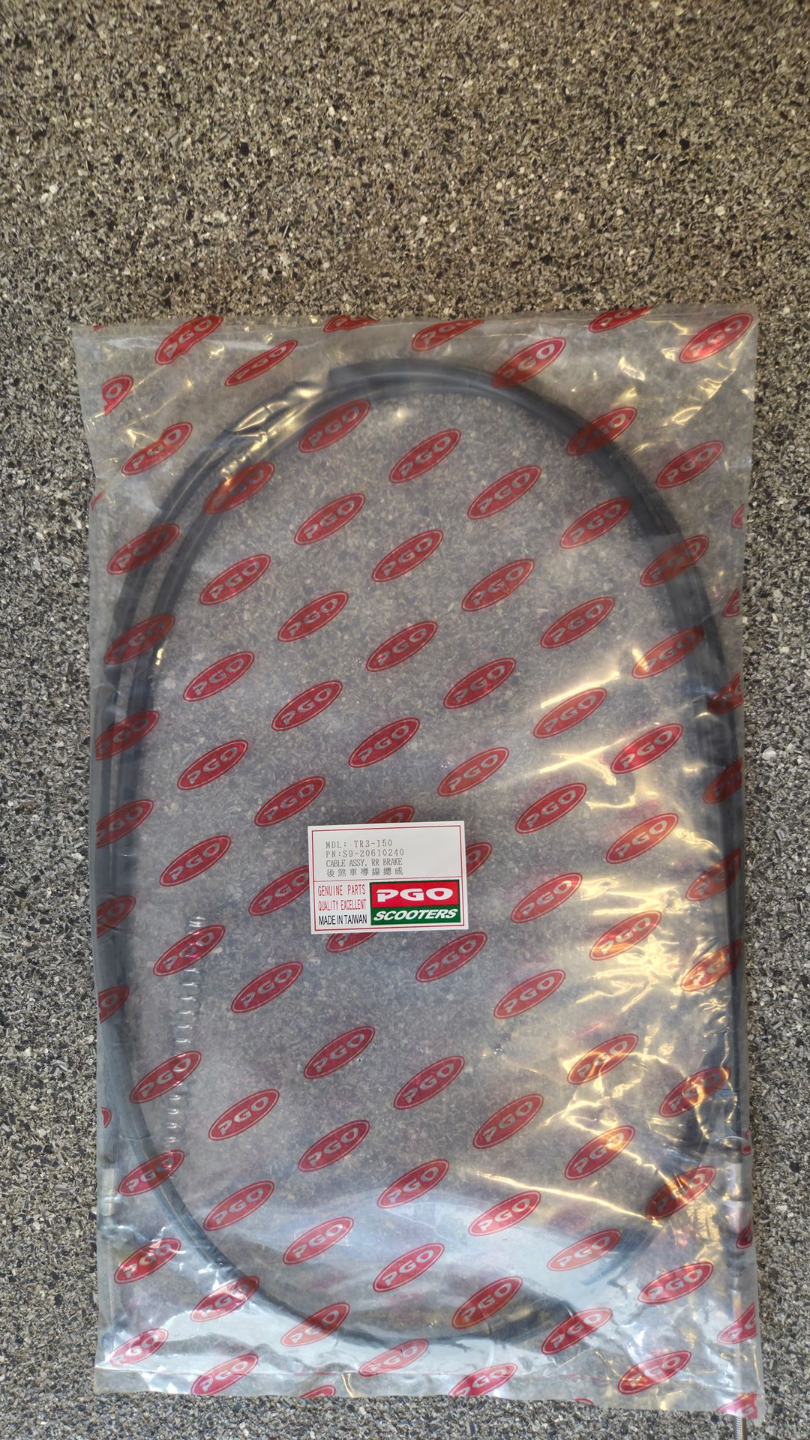 Doorzichtige plastic verpakking met een opgerolde grijze kabel en een rood etiket op een vloerbedekking.