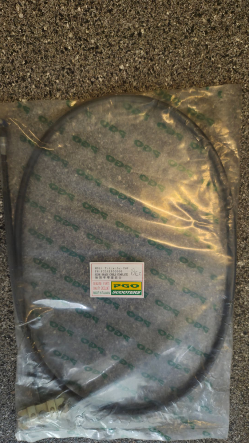 Een opgerolde zwarte kabel, verpakt in transparant plastic, op een grijze ondergrond met een klein label.