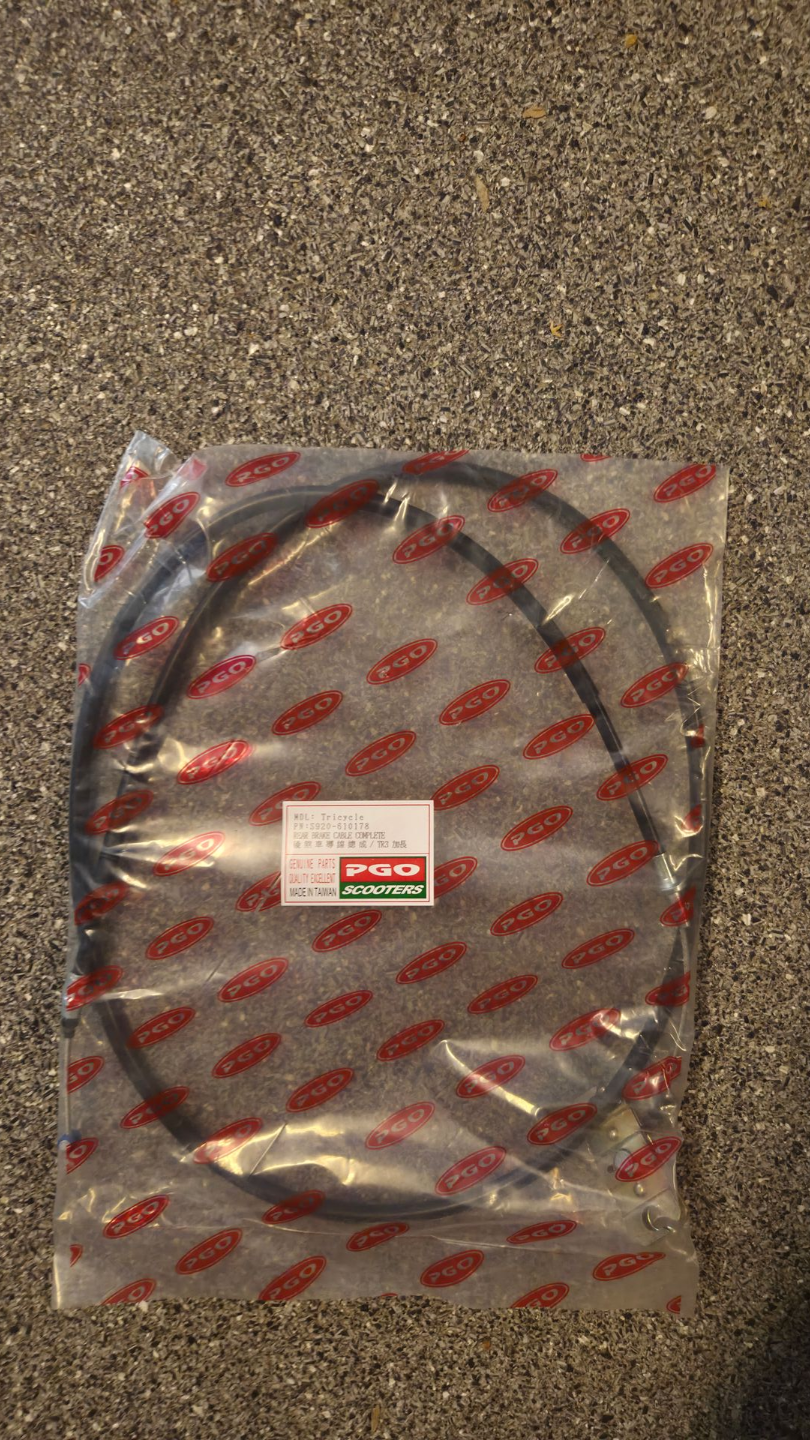Een opgerolde zwarte kabel, verpakt in transparant plastic, op een gespikkeld oppervlak.