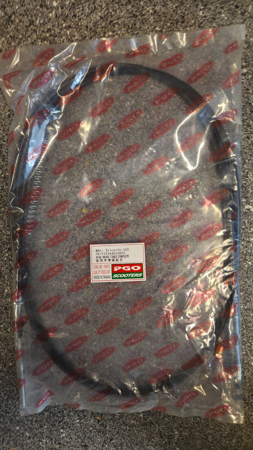 Een opgerolde zwarte kabel in een doorzichtige plastic zak met een klein rood-wit labeltje.
