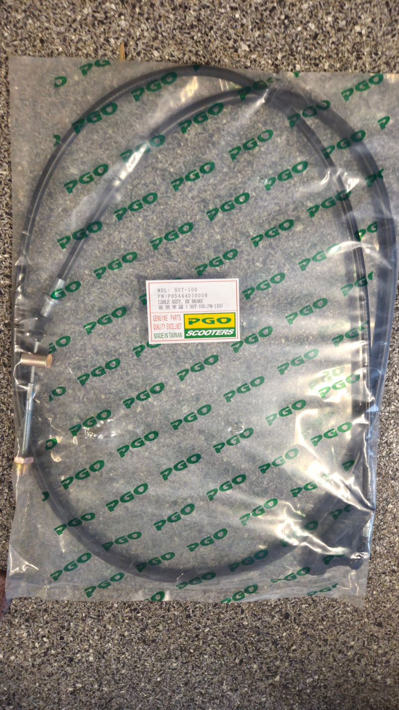 Doorzichtige plastic zak met daarin een opgerolde groene kabel met een wit-geel label op grind.