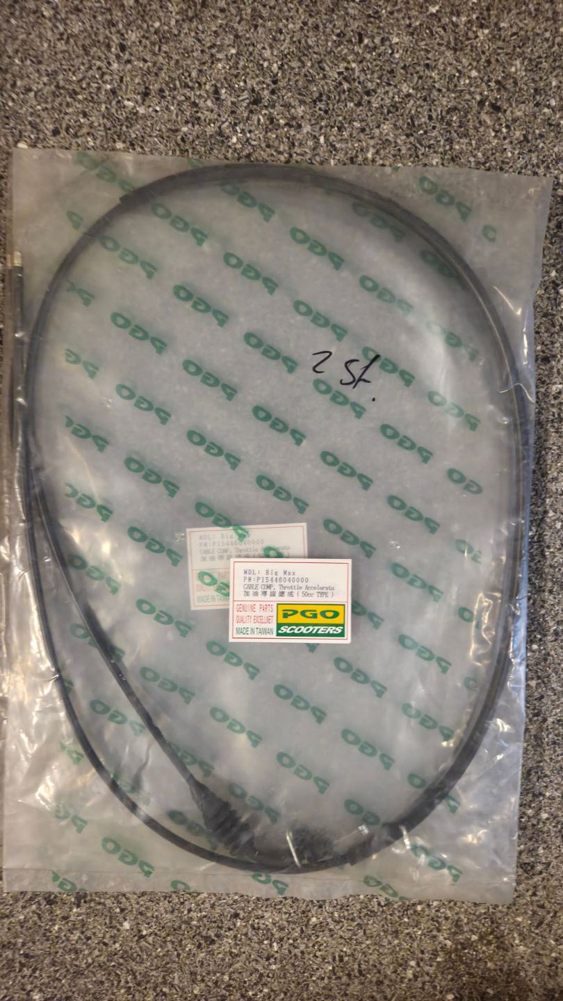 Doorzichtige plastic zak met een opgerolde zwarte kabel of slang en een klein etiket op een grijs, gestructureerd oppervlak.