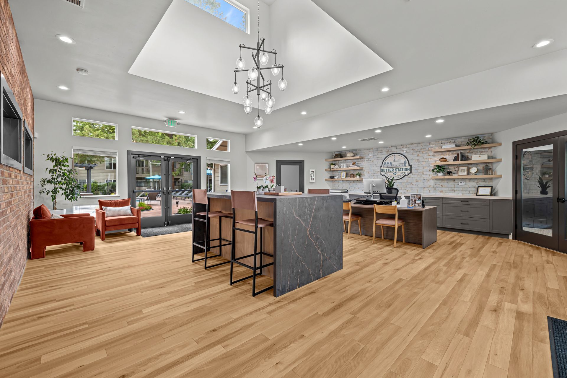 Empty modern living room with gray walls, light wood floors, fireplace, and windows with blinds