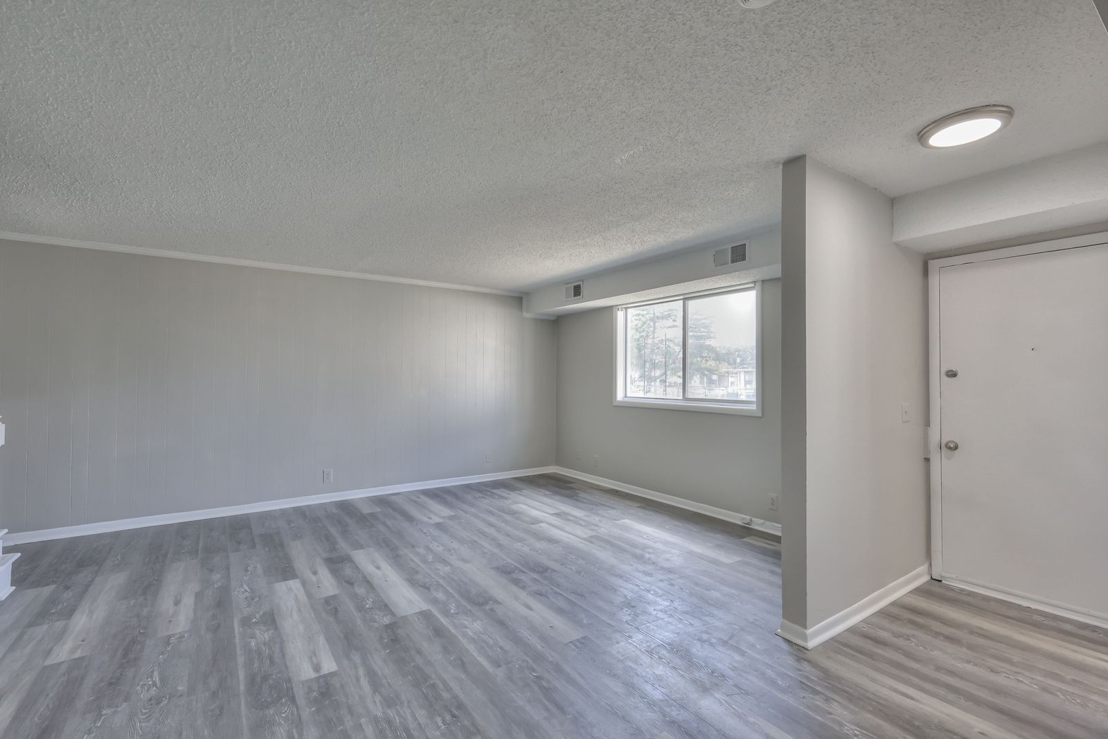 Photo of a large, open floor plan living room and the front door to the side