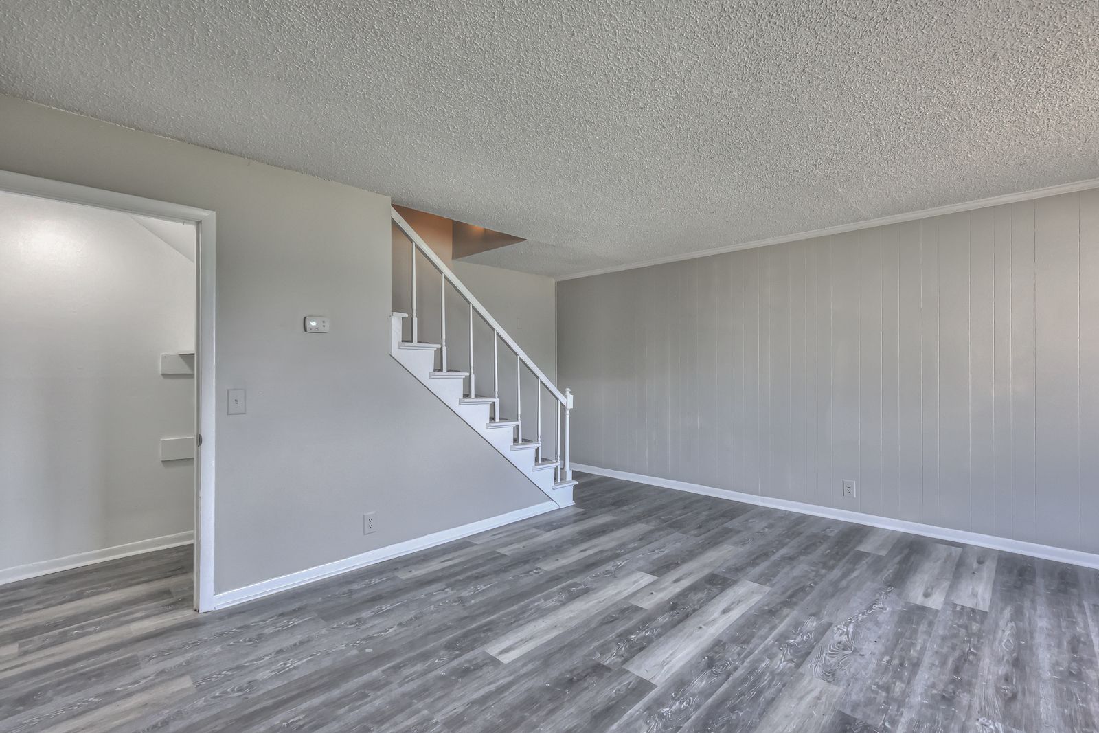 Photo of a living room with stairs leading to the second floor and a bathroom under the stairs