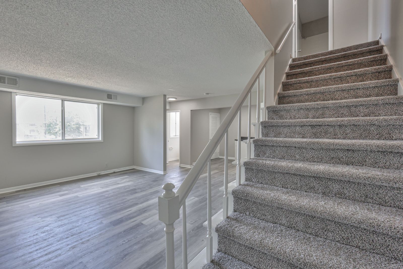 Photo of a living room with stairs leading to the second story