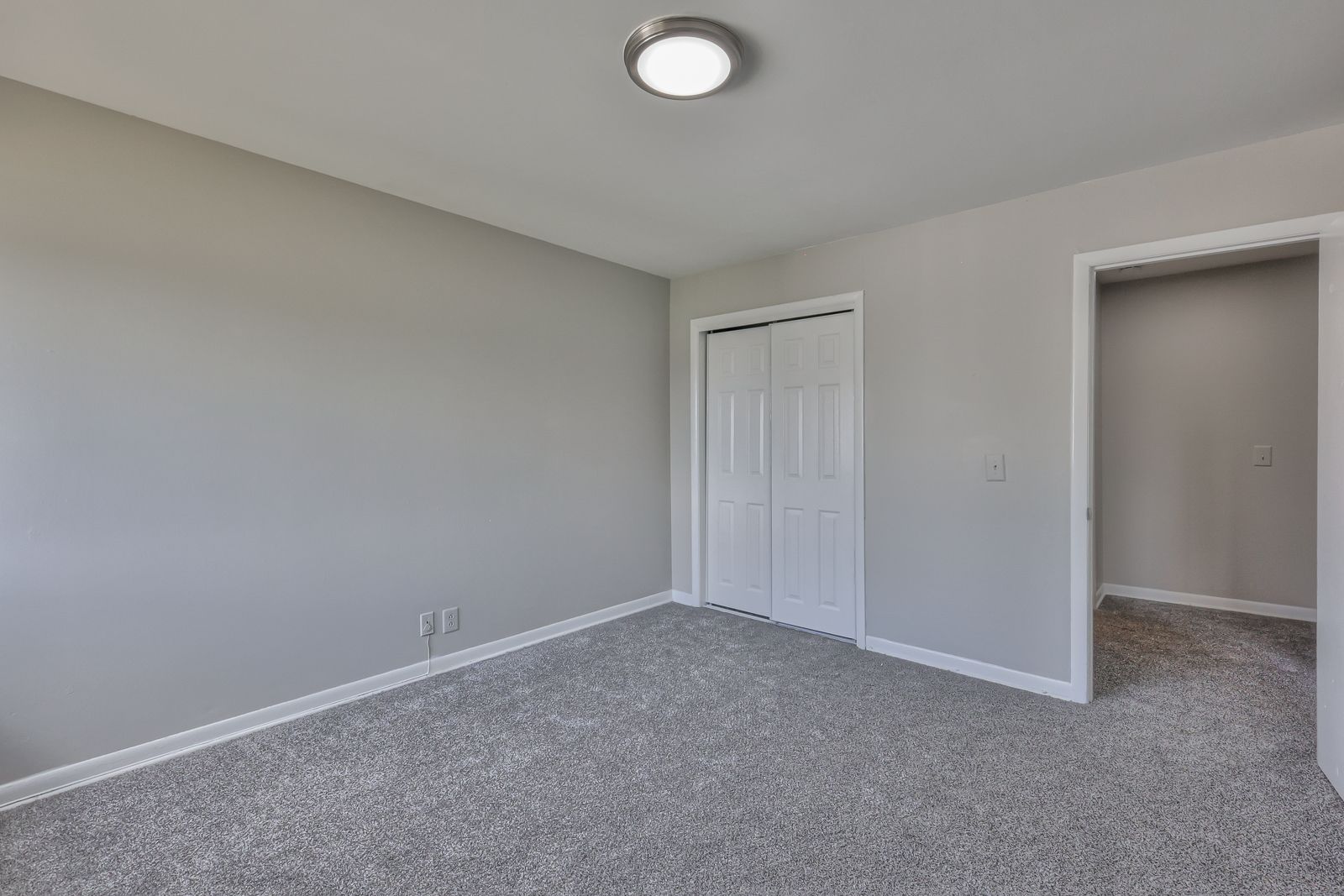 Photo of a carpeted bedroom with a dual door closet
