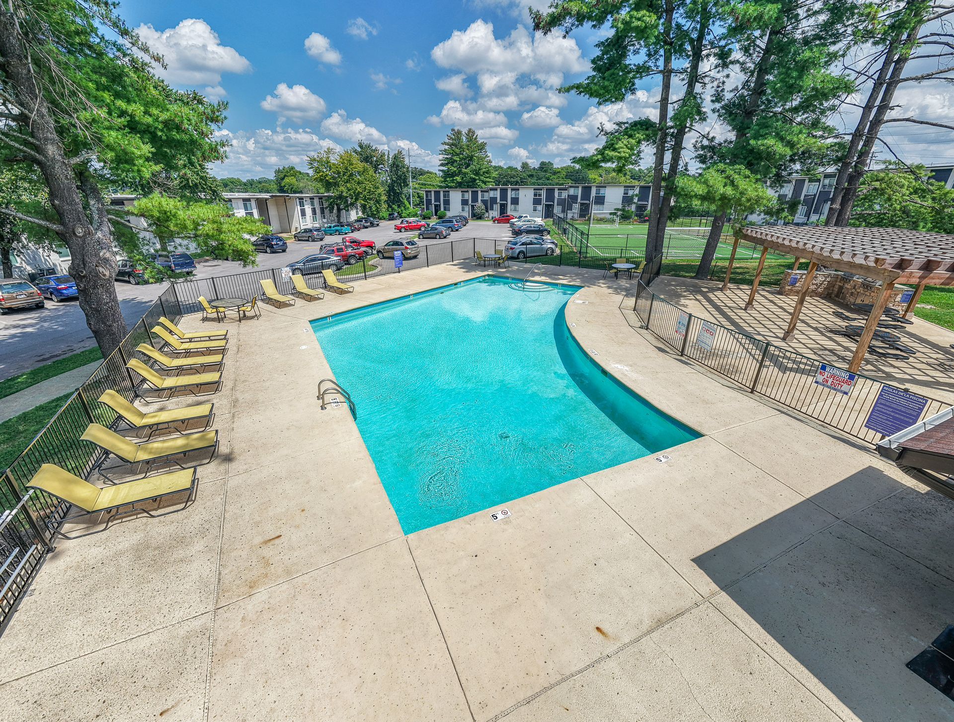 Photo of the community pool, showing the poolside chairs, and nearby gazebo