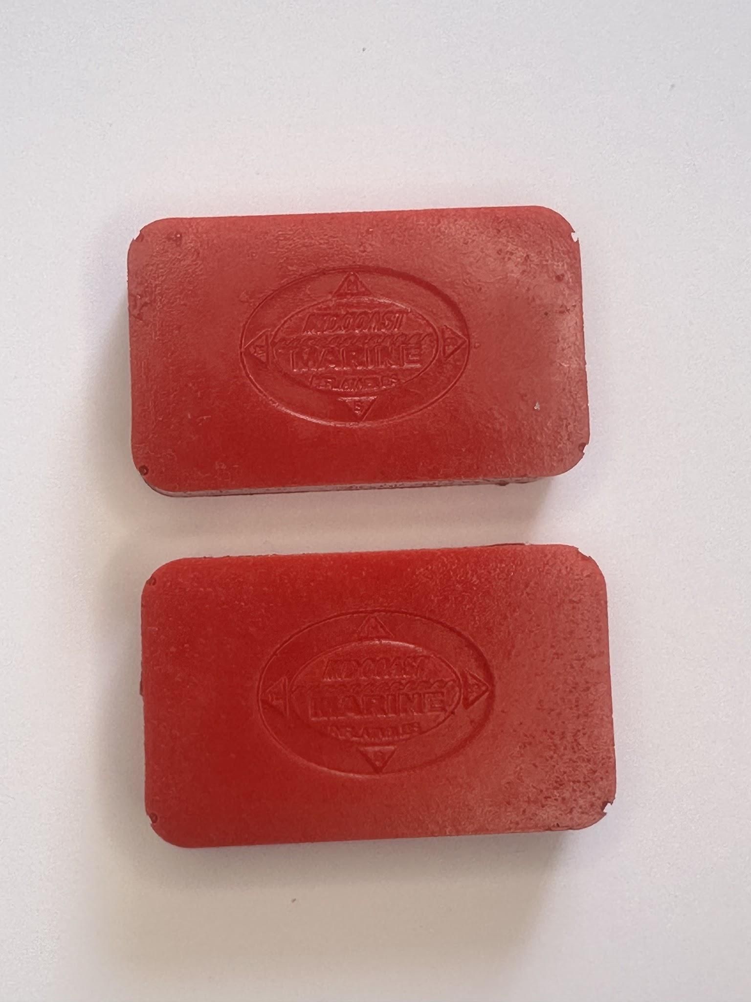 Two red rectangular soap bars stacked vertically on a white surface