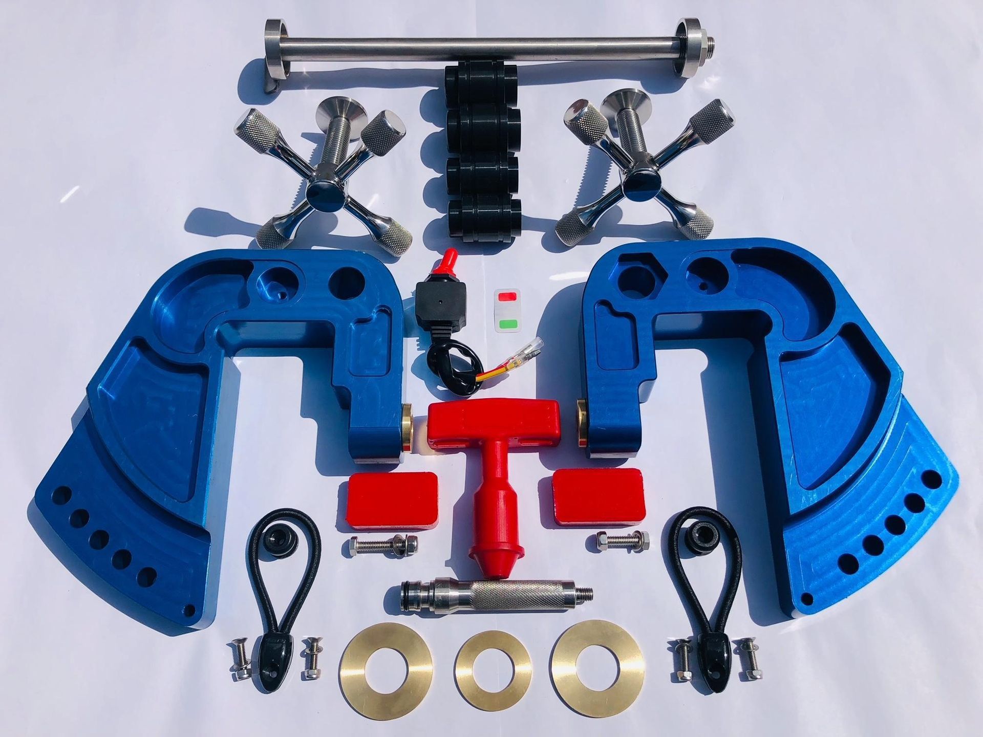 Blue suspension lift kit parts laid out on a white background with bolts, bushings, and hardware