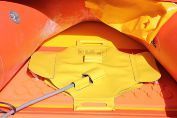 Close-up of a yellow plastic device with a metal rod, surrounded by orange curved panels.