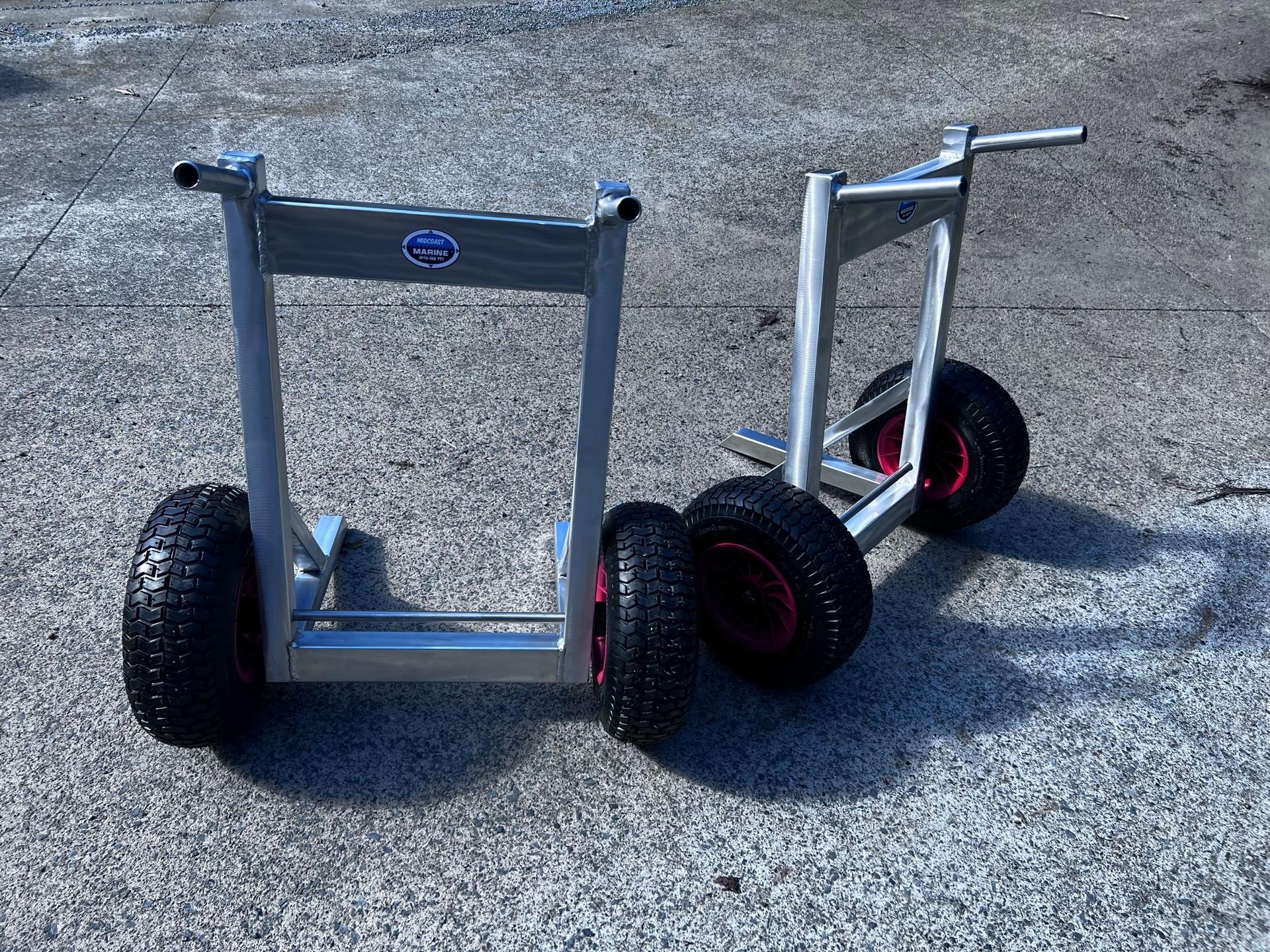 Three wheeled aluminum carts with black tires on gravel