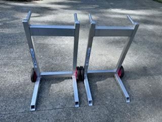 Two metal hand trucks standing side by side on pavement