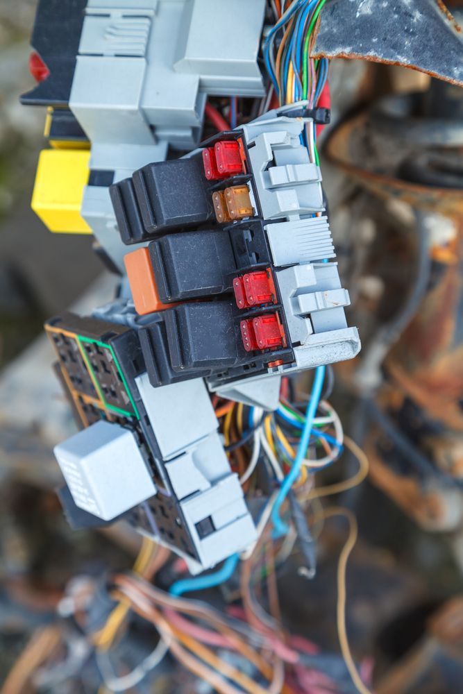 Electrical Components with Multi-Colored Wires, Including Several Fuse Boxes with Red, Black, and Orange Fuses — Townsville Electrical and Appliance Repairs In Belgian Gardens, QLD