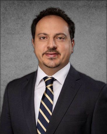 A man in a suit and tie is smiling for the camera