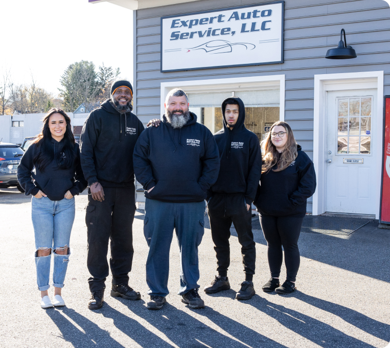 Five people standing outside Expert Auto Service, LLC with the shop sign behind them. | Expert Auto Service & Licensing