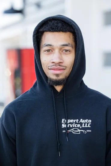 Person in a black hoodie standing outdoors with a neutral expression. | Expert Auto Service & Licensing