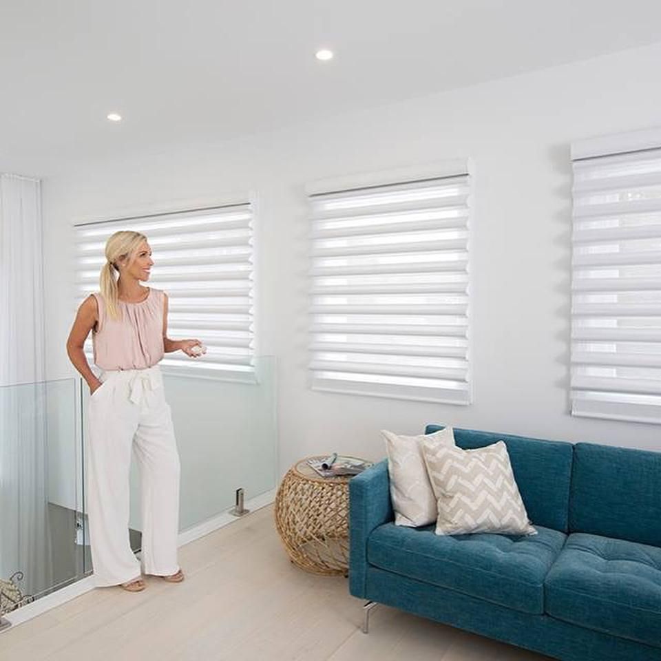 Woman Standing Near Blue Sofa With Window Blinds — JSF Interiors Goulburn in Moss Vale, NSW