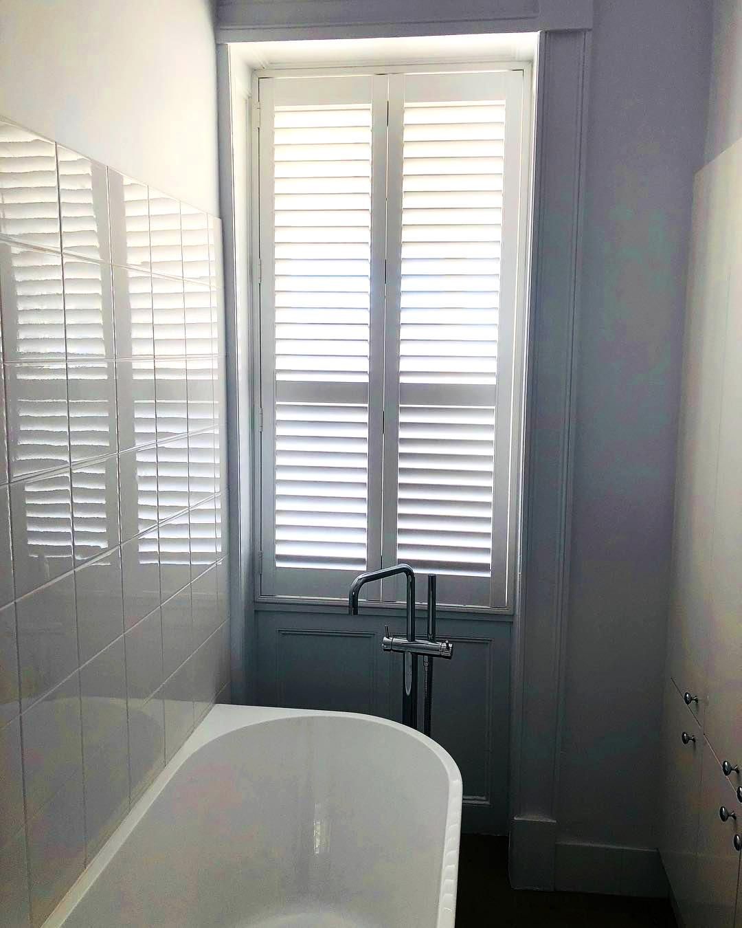 White Bathroom With Bathtub And Shutters — JSF Interiors Goulburn in Albion Park, NSW
