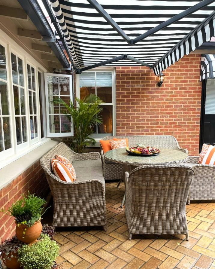 Patio With Wicker Furniture And Striped Awning — JSF Interiors Goulburn in Mittagong, NSW