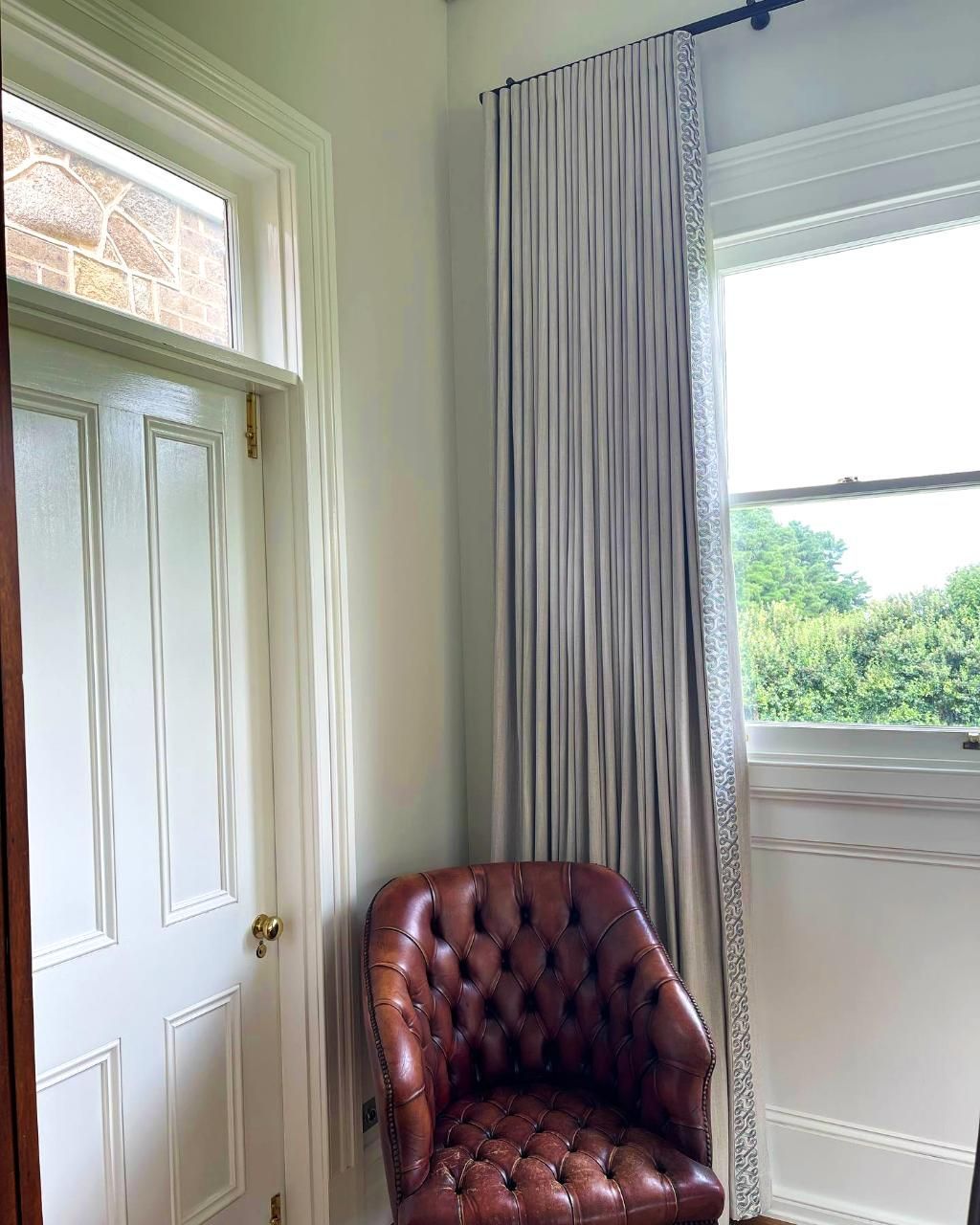 Leather Chair Near Window With Draped Curtains — JSF Interiors Goulburn in Moss Vale, NSW