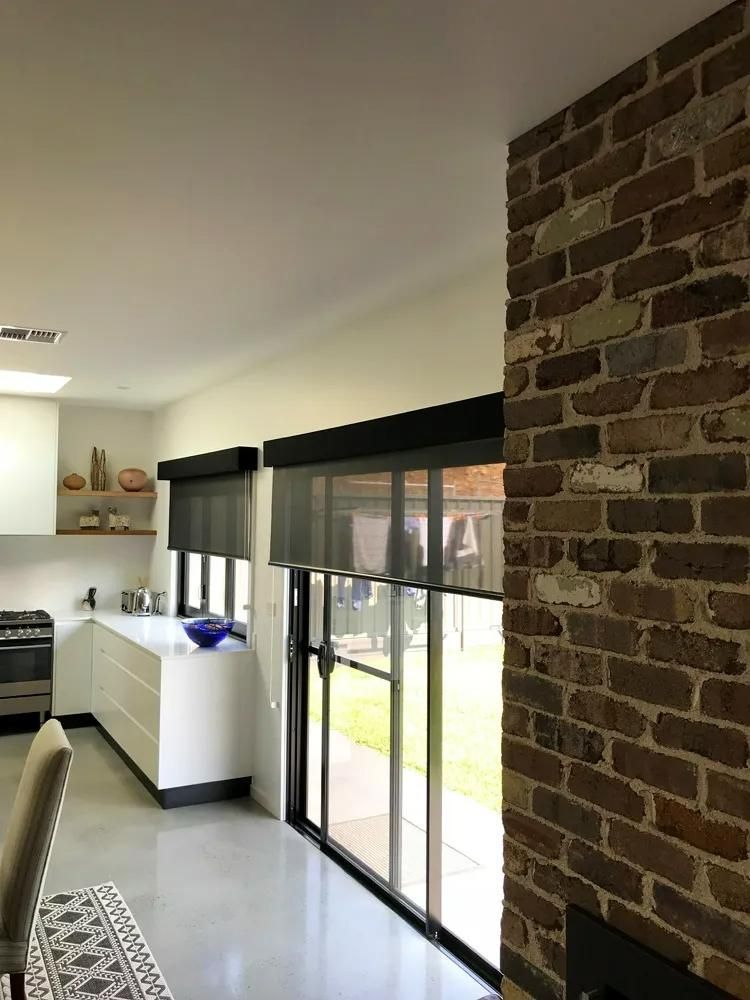 Modern Kitchen With Brick Wall And Roller Blinds — JSF Interiors Goulburn in Goulburn, NSW